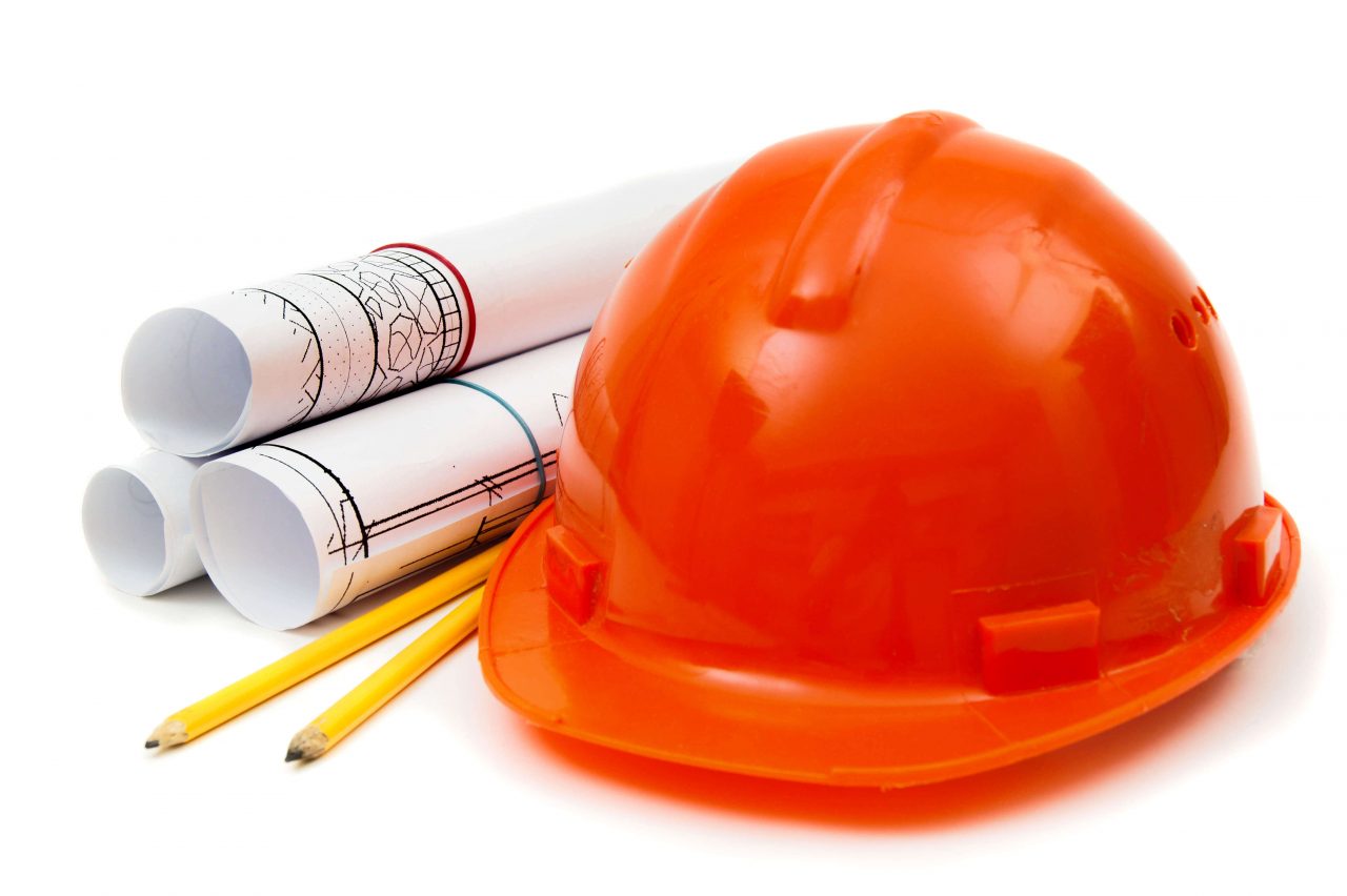 We Do Lines Arizona - An orange hard hat, two yellow pencils, and three rolled-up blueprints are placed on a white background, reminiscent of the precise planning needed for line striping.