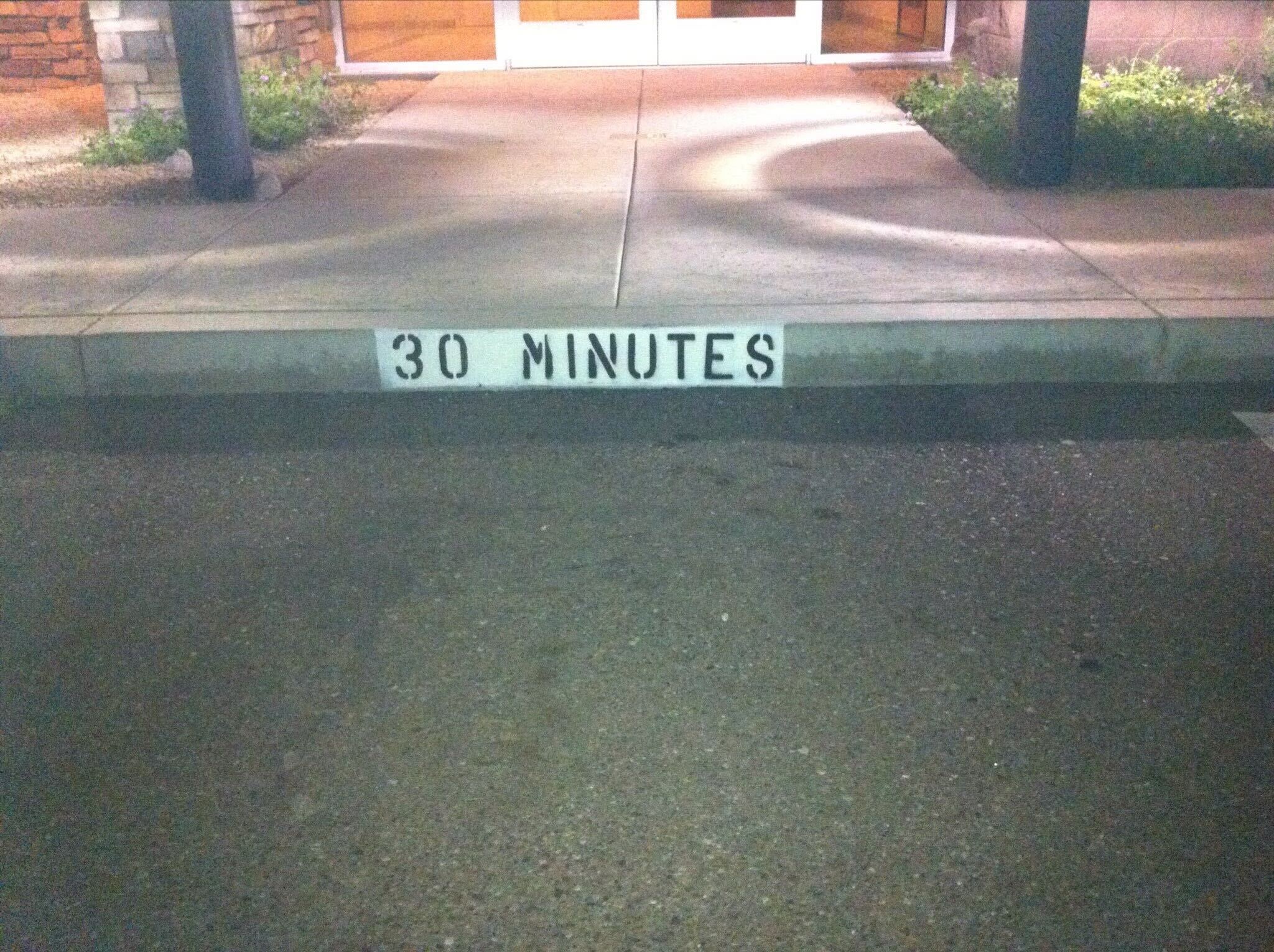 We Do Lines Arizona - Curbside parking spot with "30 MINUTES" painted in white text, featuring clear line striping to indicate a time limit for parking.